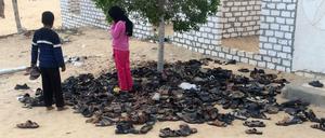 Kinder betrachten vor der Moschee in Bir al-Abd (Ägypten) die Schuhe von Opfern des Terroranschlags.