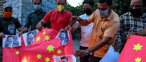 Indische Anti-China-Aktivisten zünden eine chinesische Flagge und Fotos des KP-Chefs Xi Jinping an.