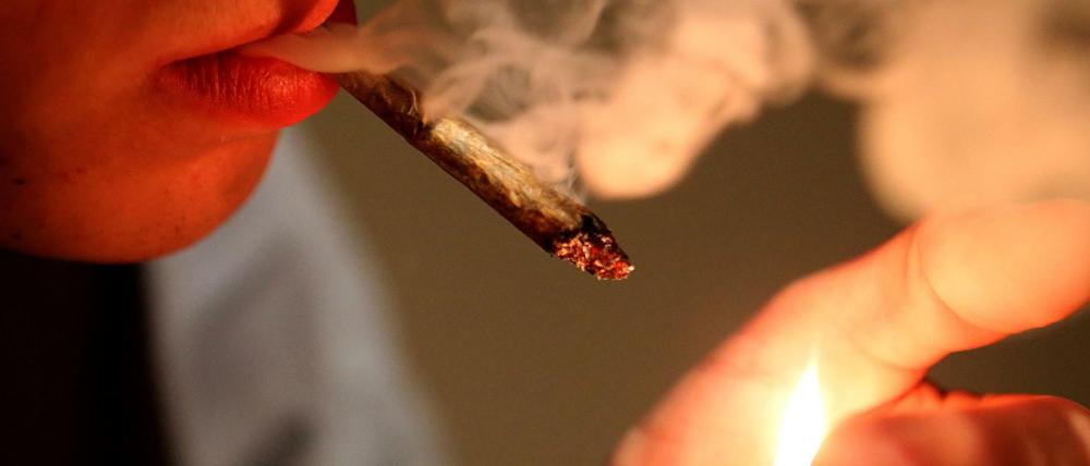 Ein Mann raucht einen Joint. Die Linke will Cannabis-Konsum entkriminalisieren. 