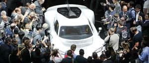 Besucher der Automesse in Frankfurt betrachten einen neuen Sportwagen von Mercedes AMG. 