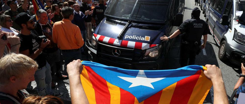 Linksnationalistische Katalanen blockieren die Bundespolizei nach ihrem Einsatz in Barcelona. Vorne die Fahne der Separatisten.