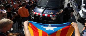 Linksnationalistische Katalanen blockieren die Bundespolizei nach ihrem Einsatz in Barcelona. Vorne die Fahne der Separatisten.