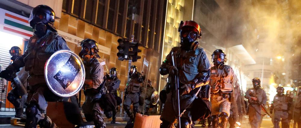 Aufruhr in Hongkong: Polizisten an einer brennenden Barrikade, die Demonstranten errichtet hatten
