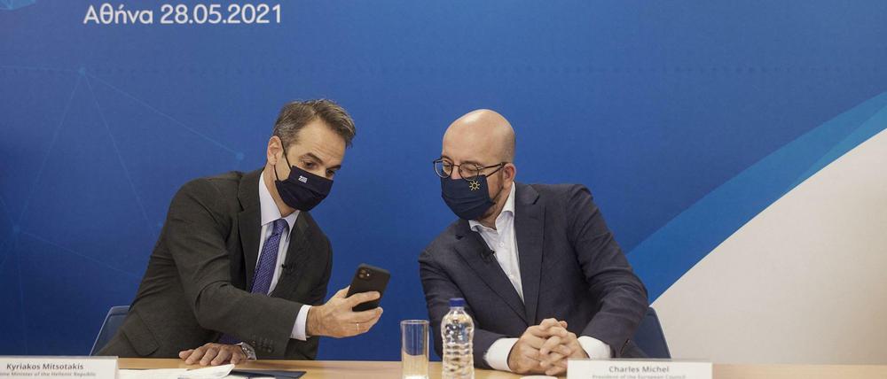 Der griechische Premierminister Mitsotakis (links) und EU-Ratschef Michel begutachten das digitale Impfzertifikat.