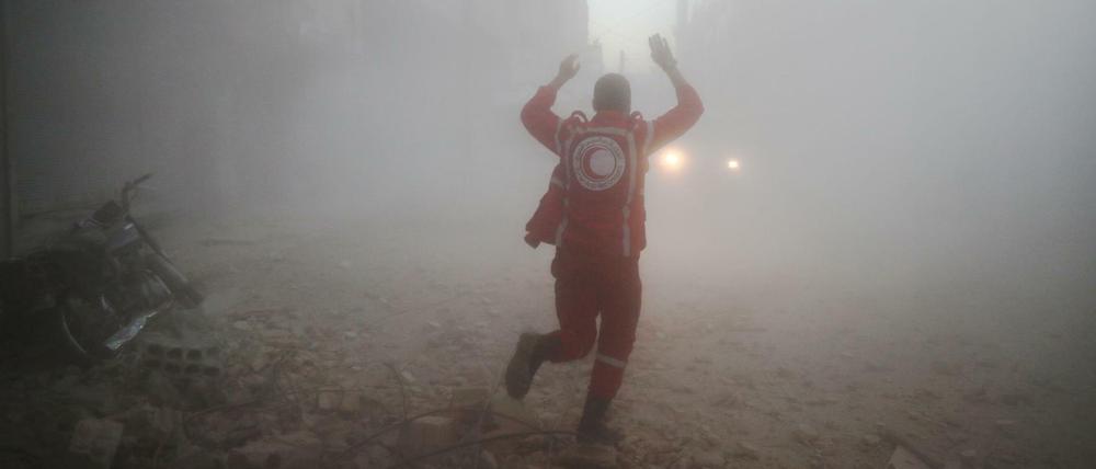 Helfer vom Syrischen Roten Halbmond suchen in dem von Rebellen kontrollierten Ort Douma nach Opfern eines Luftangriffs.