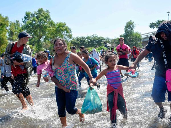 Mit Kind und Plastiktüte versuchen Migranten, den Grenzfluss Richtung Mexiko zu überqueren.