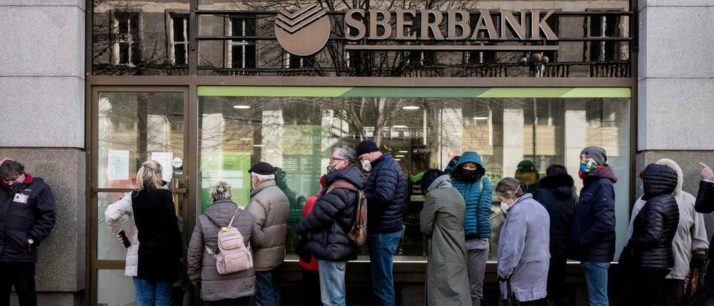 Bankkunden stehen vor einer Sberbank-Filiale in Prag Schlange. 