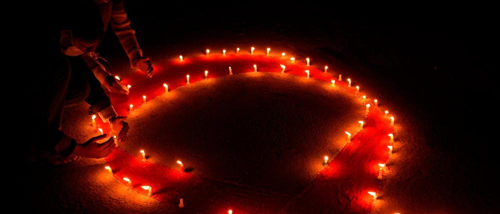 Am Vorabend des Welt-Aids-Tages. Aktivisten in Kathmandu entzünden Kerzen in Form der symbolischen roten Schleife. 