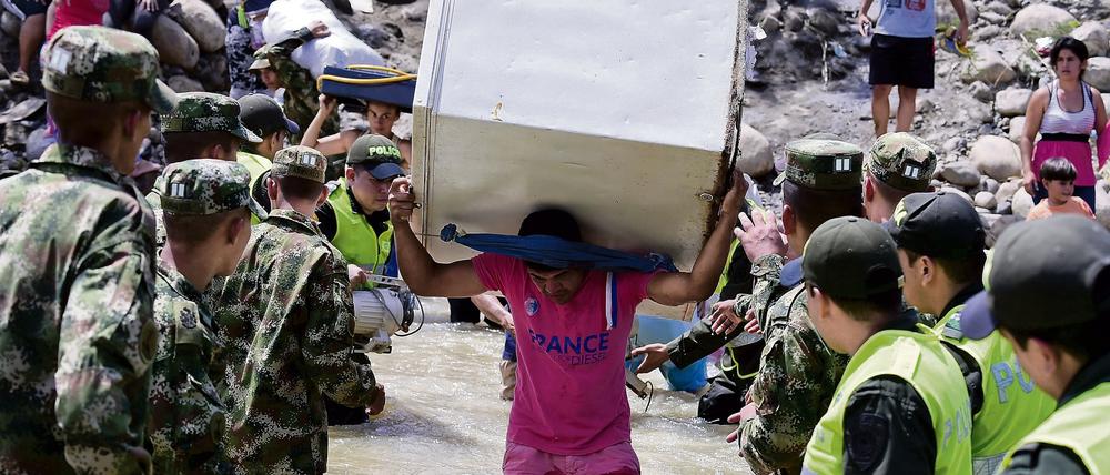 Ein Kolumbianer schleppt offenbar einen Kühlschrank über den Grenzfluss Tachira aus Venezuela nach Cucuta, Kolumbien.  