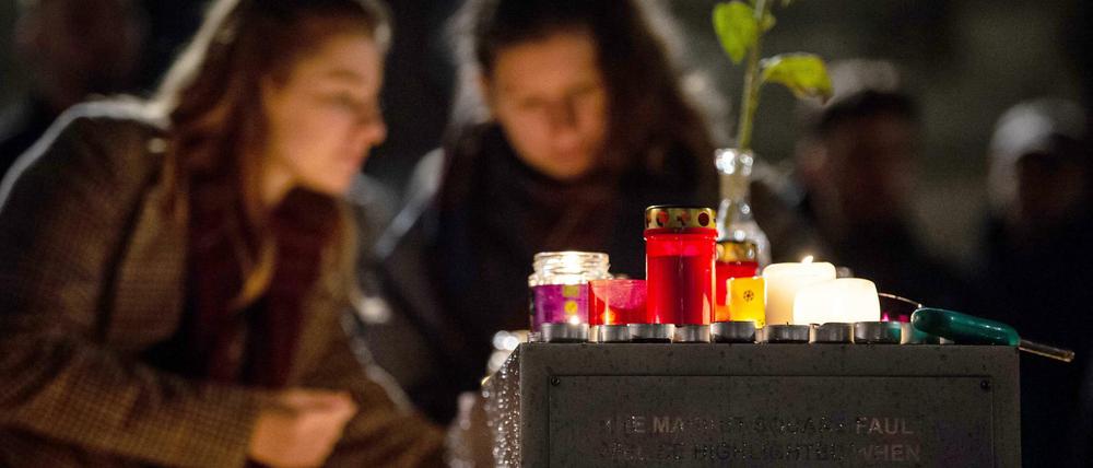 Zwei Frauen zünden eine Kerze auf dem Marktplatz zum Gedenken an die Opfer an. 