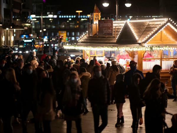 Besucher stehen am Samstag des zweiten Adventswochenendes vor einer Weihnachtsbude am Breitscheidplatz. 