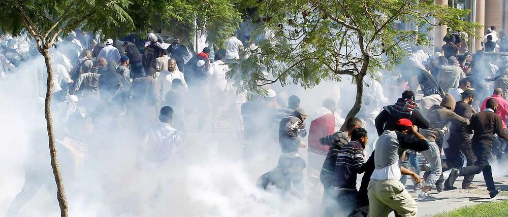 Demonstranten in der tunesischen Hauptstadt flüchten vor den Tränengasgeschossen der Sicherheitskräfte.