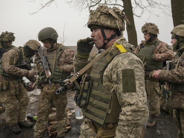 Ukraine, Region Donezk: Ukrainische Soldaten stehen zusammen und rauchen.