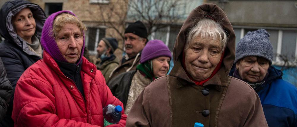 Ukrainische Frauen warten darauf, kostenloses Essen aus einer Suppenküche zu erhalten.