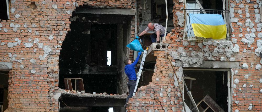 Bewohner holen Habseligkeiten aus einem zerstörten Haus in Irpin.