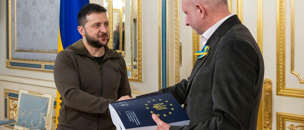 Wolodymyr Selenskyj (l) überreicht Matti Maasikas, Leiter der Delegation der EU in der Ukraine, den beantworteten Fragebogen für einen EU-Beitritt.