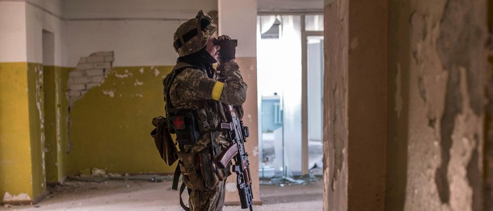Ein ukrainischer Soldat blickt während schwerer Kämpfe an der Frontlinie in Sjewjerodonezk in der Region Luhansk durch ein Fernglas.