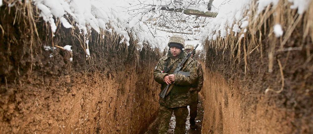 Im Mittelpunkt des Konflikts: Ein Ukrainischer Soldat patroulliert in einem Schüztengraben an der Grenze zum Territorium der von Russland unterstützten Separatisten.