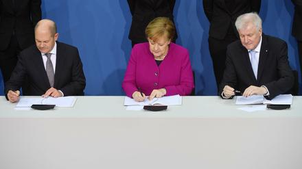 Wie lange noch? Olaf Scholz (SPD), Angela Merkel (CDU) und Horst Seehofer (CSU) beim Unterschreiben des Koalitionsvertrags im März 2018. Foto: dpa.