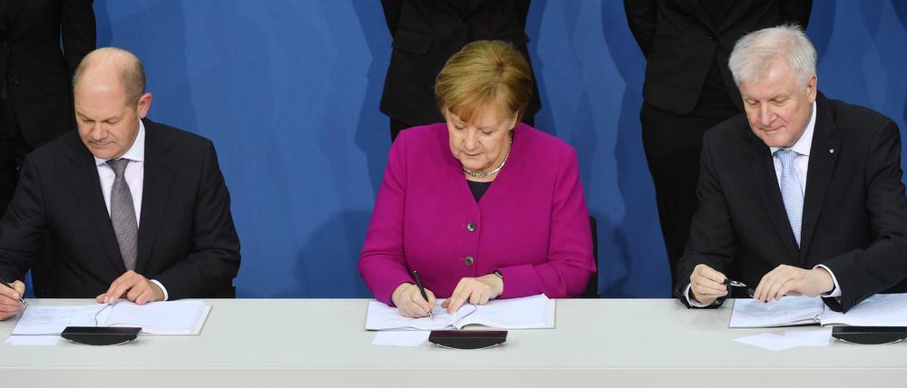Wie lange noch? Olaf Scholz (SPD), Angela Merkel (CDU) und Horst Seehofer (CSU) beim Unterschreiben des Koalitionsvertrags im März 2018. Foto: dpa.