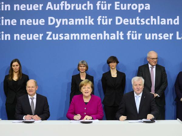 Angela Merkel, Horst Seehofer (r) und Olaf Scholz unterzeichnen den Koalitionsvertrag. 