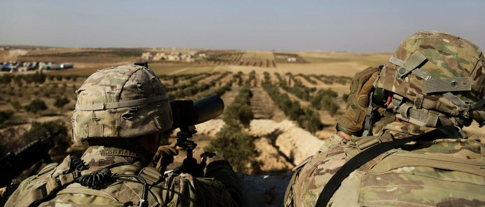 Zwei US-Soldaten schauen von ihrer Basis in Syrien zur türkischen Grenze hinüber. Trump will die US-Truppen abziehen.