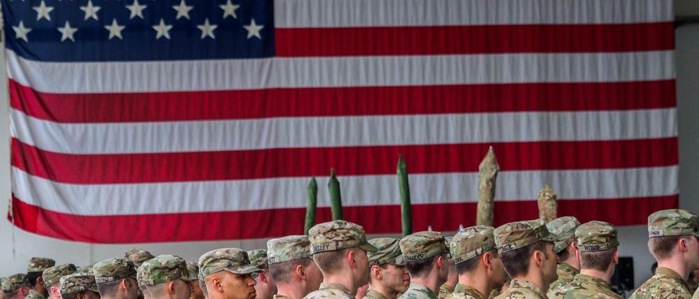 US-Soldaten stehen während einer militärischen Zeremonie in den Storck-Barracks in Baern vor einer Flagge der Vereinigten Staaten von Amerika.