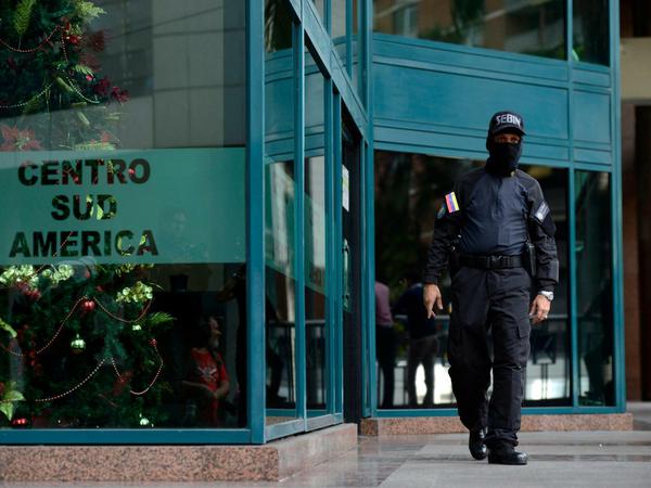 Ein Beamter des venezolanischen Geheimdienstes Sebin am Eingang des Gebäudes, in dem Guaidós Büro liegt