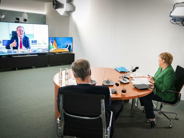 Kanzlerin Merkel und CSU-Chef Söder im Kanzleramt bei der Videoschalte, im Gespräch mit NRW-Ministerpräsident Armin Laschet. 