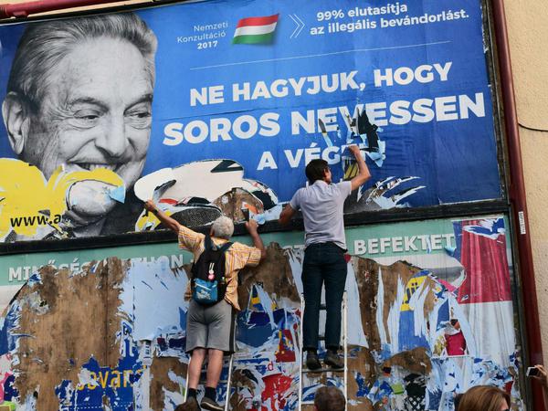 Egyutt-Aktivisten zerreißen Plakate in Budapest.