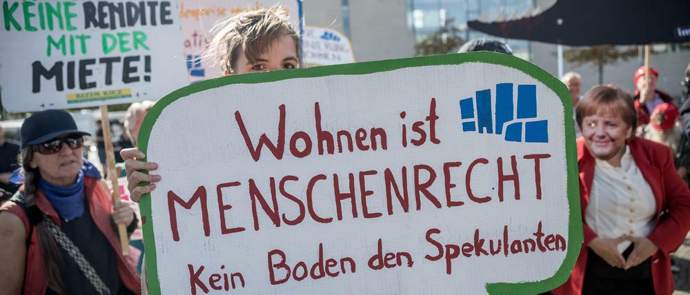 Demonstranten des "Bündnis #Mietenwahnsinn" stehen mit einem Schild "Wohnen ist Menschenrecht" vor Beginn des Wohngipfels vor dem Bundeskanzleramt.