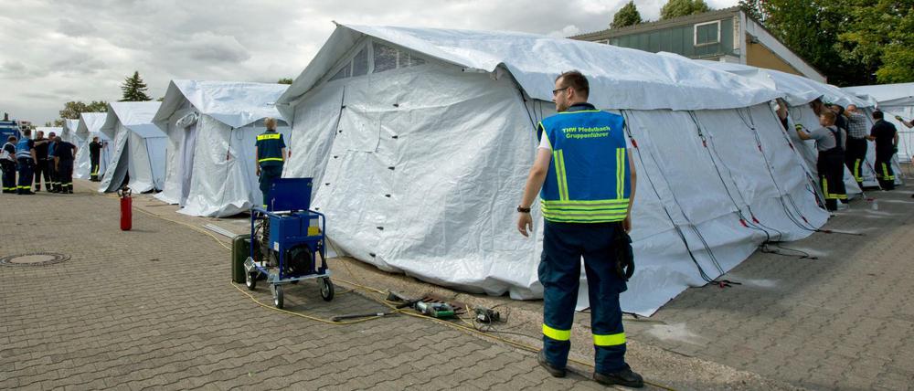 Mitarbeiter des Technischen Hilfswerks bauen in Neuenstadt am Kocher (Baden-Württemberg) ein Zeltlager als Notunterkunft für 200 Flüchtlinge auf dem Gelände einer ehemaligen Autobahnmeisterei auf. 