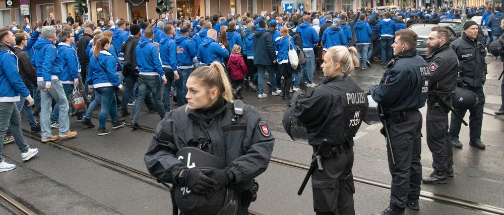 Eine Stadt im Fußball-Wahn. Polizeibeamte beobachten am Boxhagener Platz den Abzug von Hertha-Fans auf ihrem Weg zum Fußballspiel gegen Union in Köpenick. 