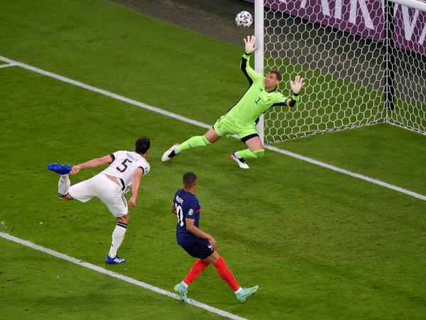 Mats Hummels beim Eigentor gegen Torwart Manuel Neuer. Der Franzose Kylian Mbappe (mitte) schaut dem Ball hinterher.