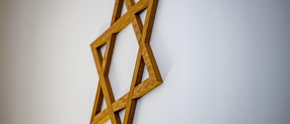  Ein Davidstern hängt an einer Wand im Gebetsraum einer Synagoge (Symbolbild).