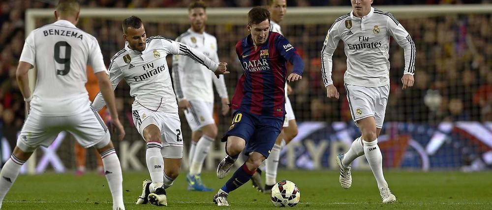 Barcelonas Torjäger Lionel Messi (Mitte) lässt sich nicht aufhalten. Auch nicht von Weltmeister Toni Kroos (re.).