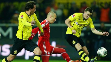 Die Dortmunder Manuel Friedrich (links) und Kevin Großkreutz (rechts) kämpfen mit Arjen Robben vom FC Bayern um den Ball.