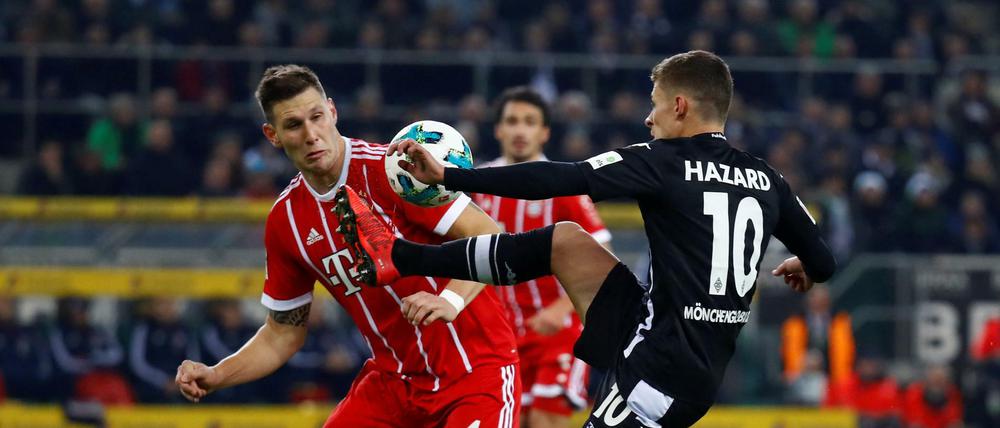 Auf dem Weg zum 1:0. Gladbachs Thorgan Hazard holte gegen Bayerns Niklas Süle den Handelfmeter heraus.