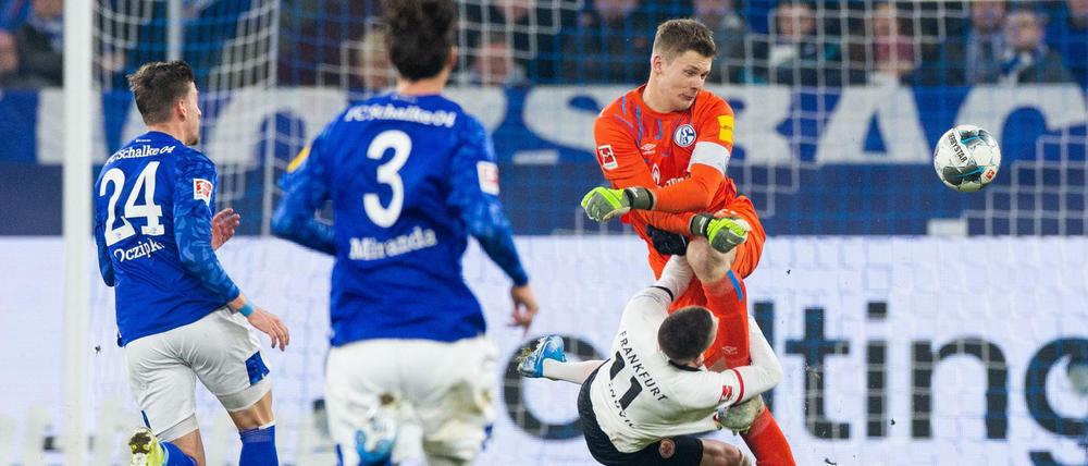 Schalkes Torwart Alexander Nübel (r) prallt mit Frankfurts Mijat Gacinovic (M) zusammen.