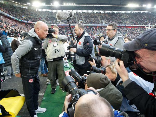 Hallo Bundesliga. Der neue Düsseldorfer Trainer Uwe Rösler (l.) wird vor dem Anpfiff von Fotografen belagert.