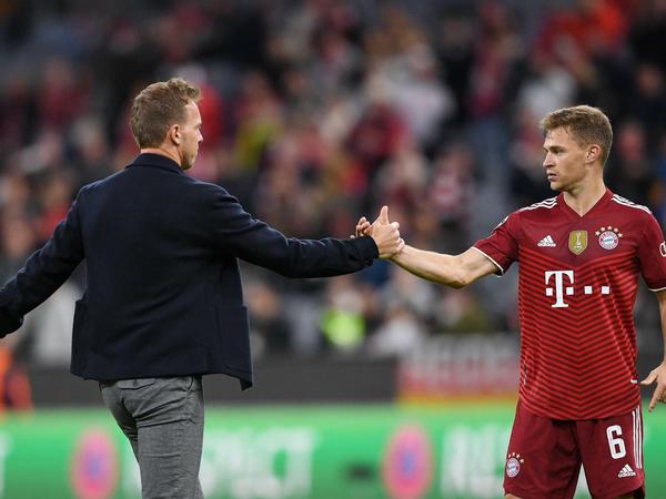 FC Bayern Münchens Trainer Julian Nagelsmann (l) klatscht mit Joshua Kimmich ab.