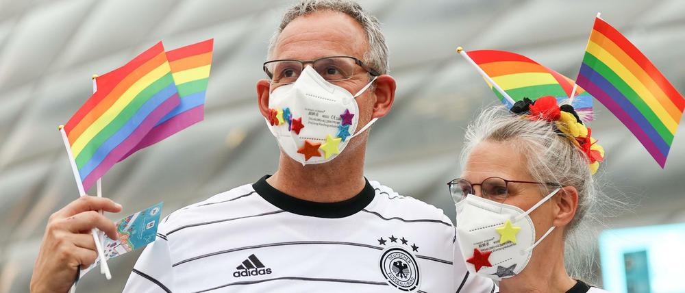Deutsche Fußballfans schwenken Regenbogenfahnen vor dem Stadion. 