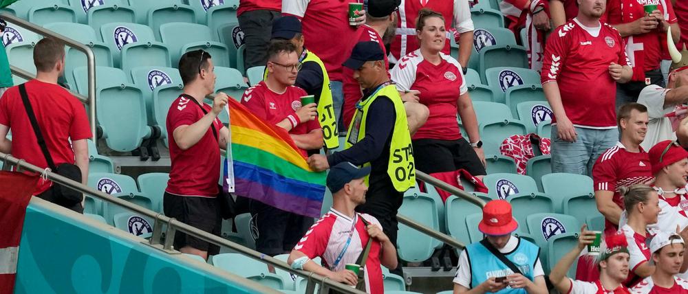 Zwei Ordner nehmen beim Spiel zwischen Dänemark und Tschechien in Baku zwei Dänemark Fans eine Regenbogen-Fahne ab.