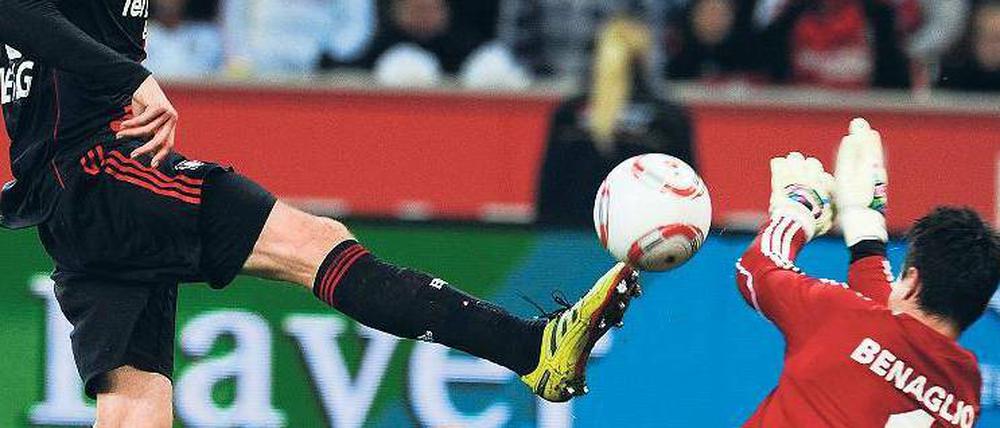 Einen Schritt schneller. Leverkusens Stefan Kießling lupft den Ball über Wolfsburgs Torhüter Diego Benaglio hinweg zum 3:0. Foto: AFP