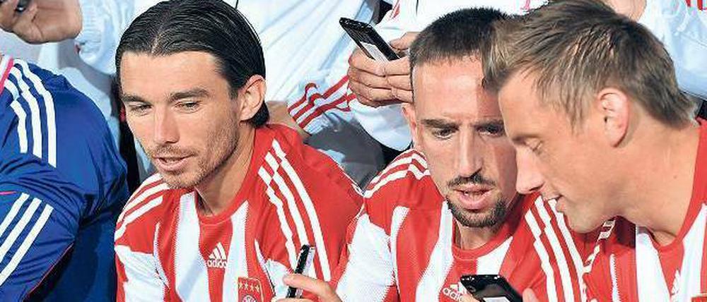 Sie haben Post. Für einen Werbetermin posieren die Bayern-Spieler Pranjic, Ribéry und Olic (v.l.) mit ihren Smartphones. Im Berufsleben könnte das ein Problem sein. Foto: p-a/dpa