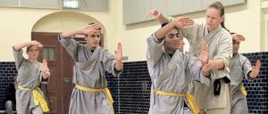 Kung-Fu-Weltmeisterin Tatjana Herrmann zeigt dem jungen Afghanen Jan die richtige Haltung. Links neben ihm steht Mohammad, der vor wenigen Monaten nach drei Jahren Flucht Deutschland erreichte. 