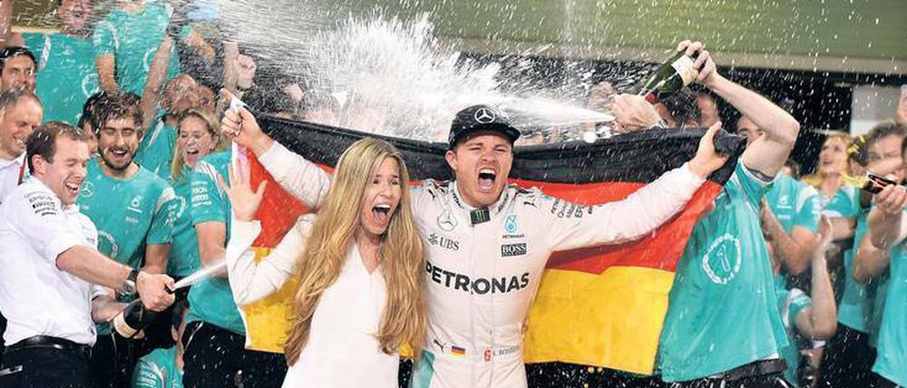 Regen nach dem Rennen. Nico Rosberg feiert mit seiner Frau Vivian den Triumph von Abu Dhabi.