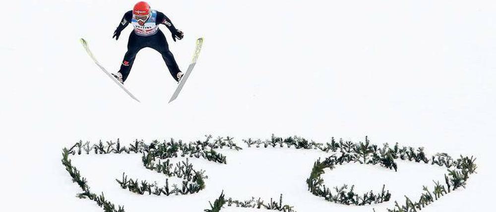 Hoch und weit. Markus Eisenbichler fliegt an der Großen Olympiaschanze über das Logo des SC Partenkirchen. 