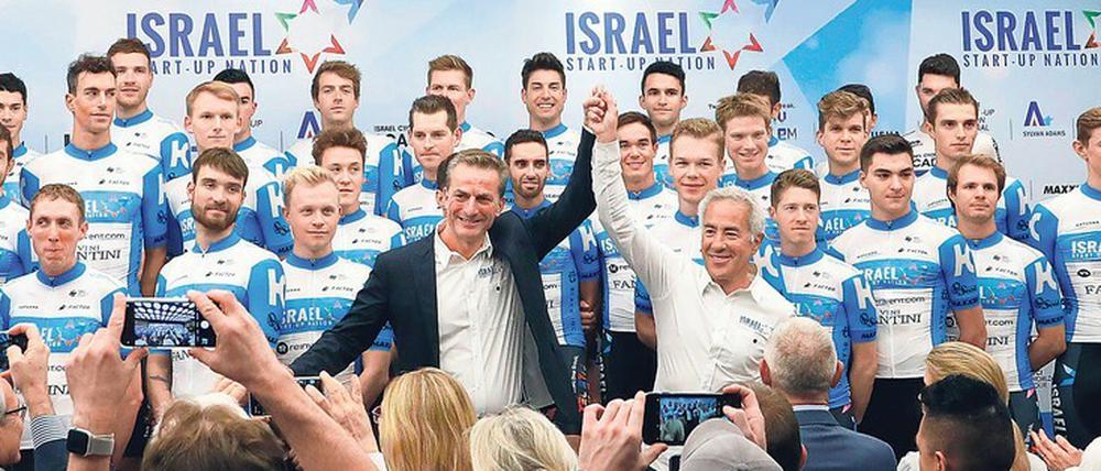 Großer Auflauf. Der kanadisch-israelische Milliardär Sylvan Adams (weißes Hemd, Mitte) bei der Vorstellung seines neuen Teams in Tel Aviv. „Warum sollen wir nicht in ein paar Jahren auch die Tour de France gewinnen?“, sagt Adams. 