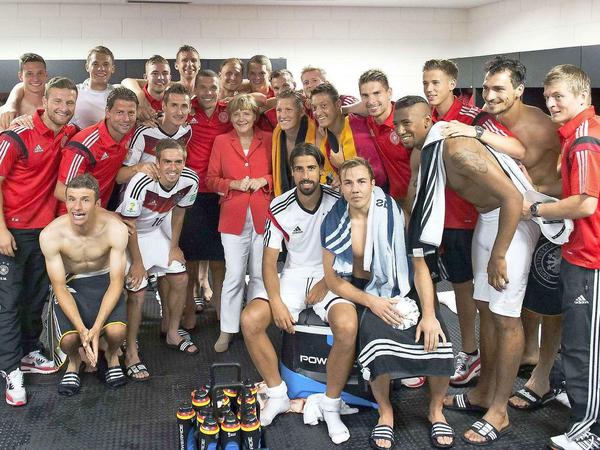 Erweitertes Selfie mit Badelatschen: Bundeskanzlerin Angela Merkel in der Kabine der Nationalmannschaft nach dem Auftaktspiel der Deutschen bei der WM 2014 in Brasilien gegen Portugal. Deutschland gewann 4:0 gegen das Team um Superstar Cristiano Ronaldo.